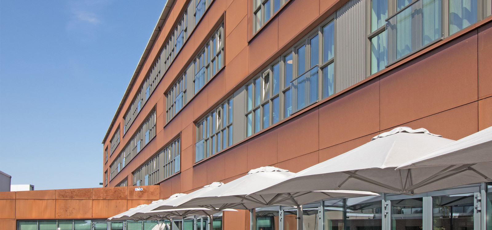 Overzicht gebouw cortenstaal en terras